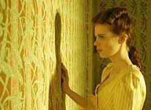 Girl staring at yellow wallpaper